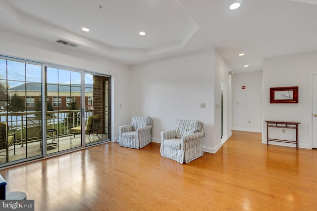 unfurnished room featuring a tray ceiling and light hardwood / wood-style flooring