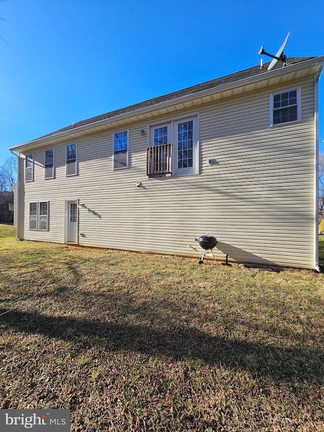 back of house with a lawn