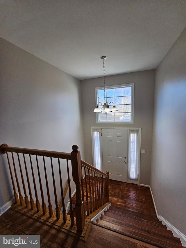 entrance foyer featuring an inviting chandelier, dark hardwood / wood-style floors, and a high ceiling