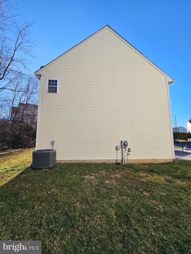 view of side of property featuring a yard and central air condition unit