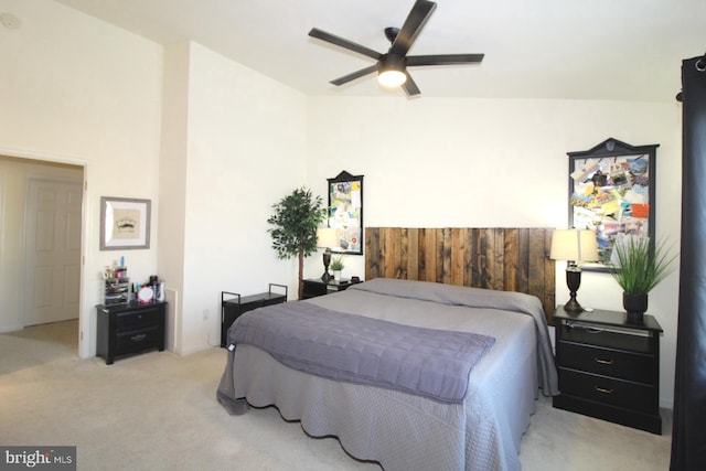 carpeted bedroom featuring ceiling fan and wood walls