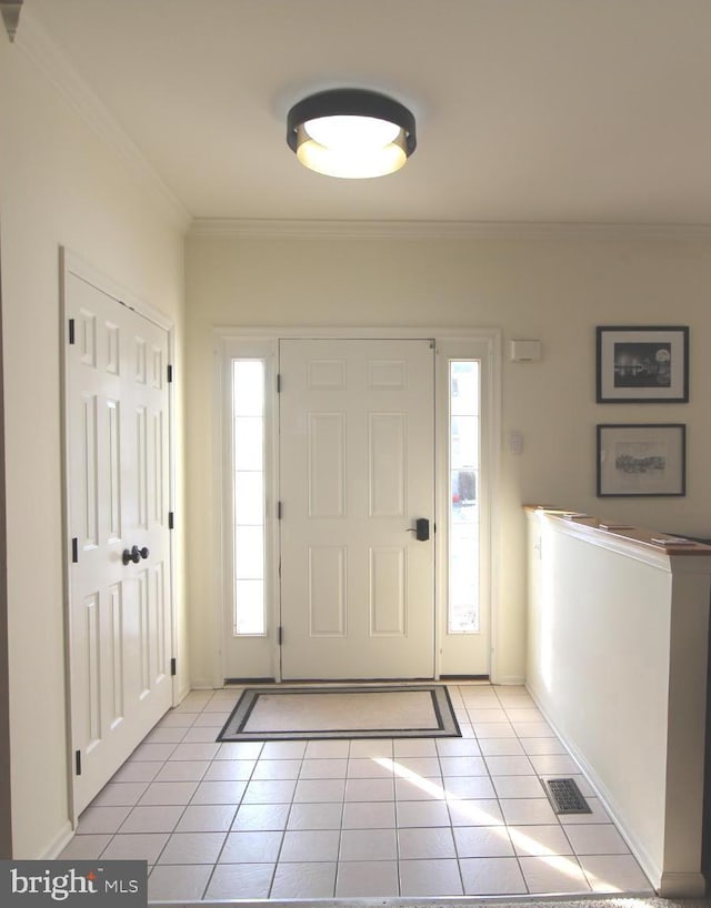 entryway featuring ornamental molding and light tile patterned floors