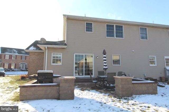 snow covered rear of property with central air condition unit