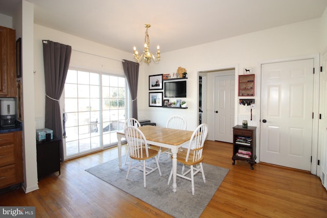 dining space featuring hardwood / wood-style flooring and an inviting chandelier