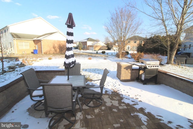 snow covered patio with area for grilling