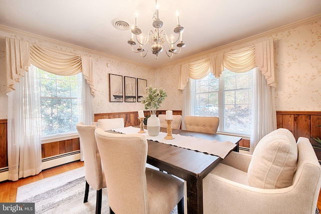 dining area with hardwood / wood-style floors, ornamental molding, a chandelier, and baseboard heating