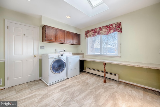 laundry area with baseboard heating, cabinets, a skylight, and washing machine and dryer