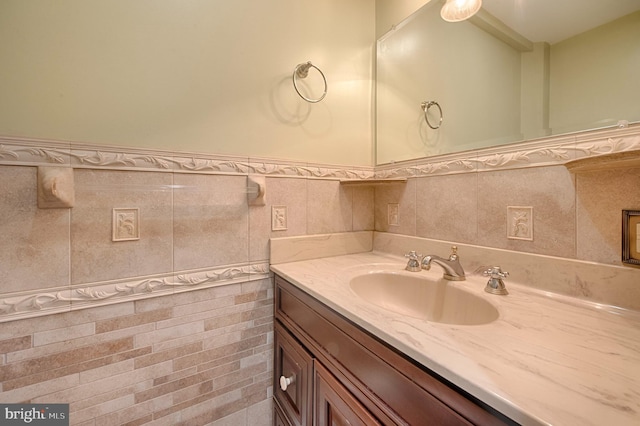 bathroom featuring vanity and tile walls