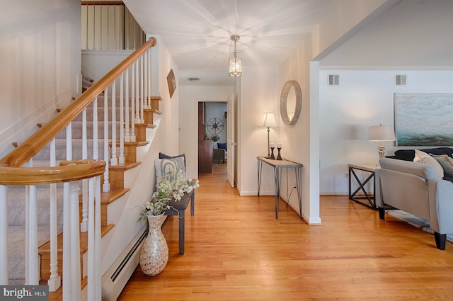 foyer with a baseboard radiator and light hardwood / wood-style flooring