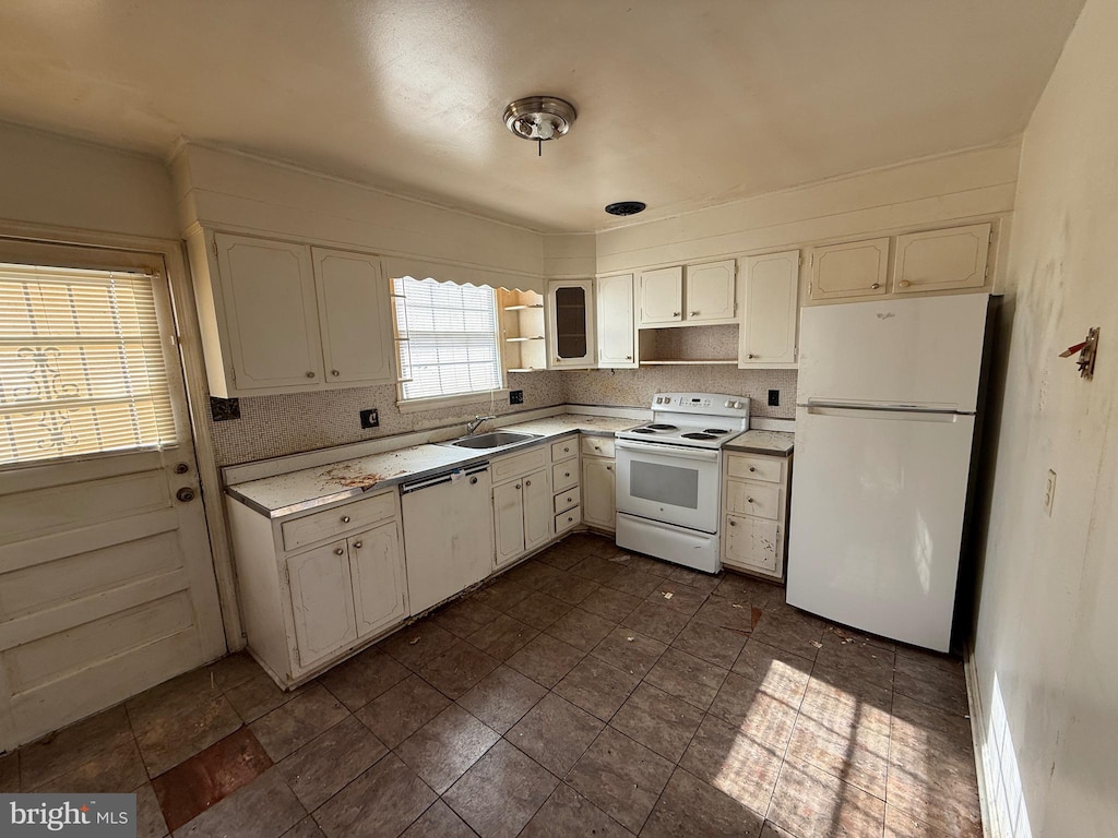 kitchen with sink, white cabinets, and white appliances