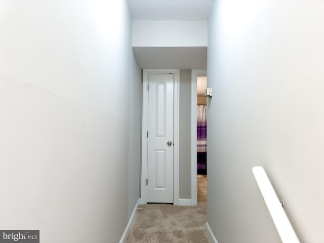 hall with light colored carpet