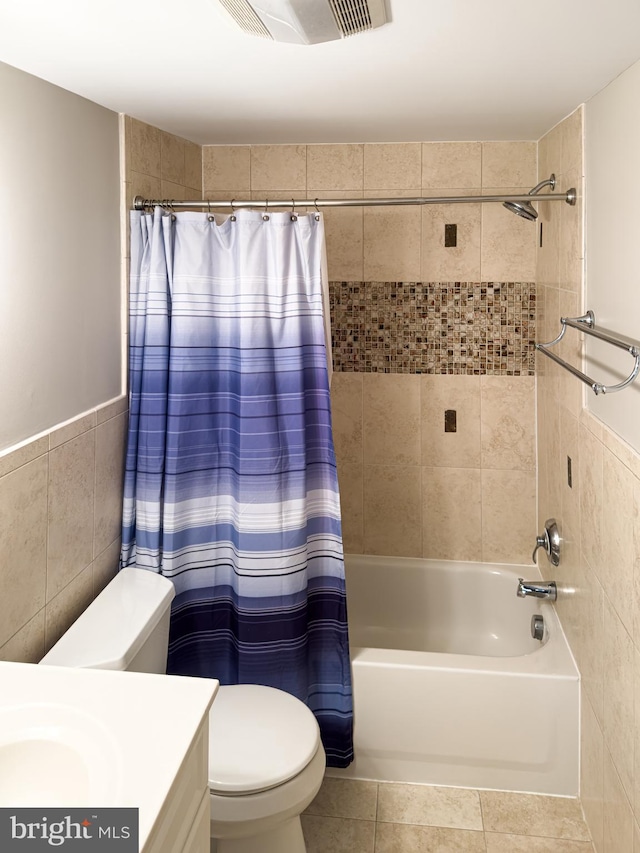 full bathroom featuring tile walls, tile patterned flooring, vanity, toilet, and shower / bath combo with shower curtain