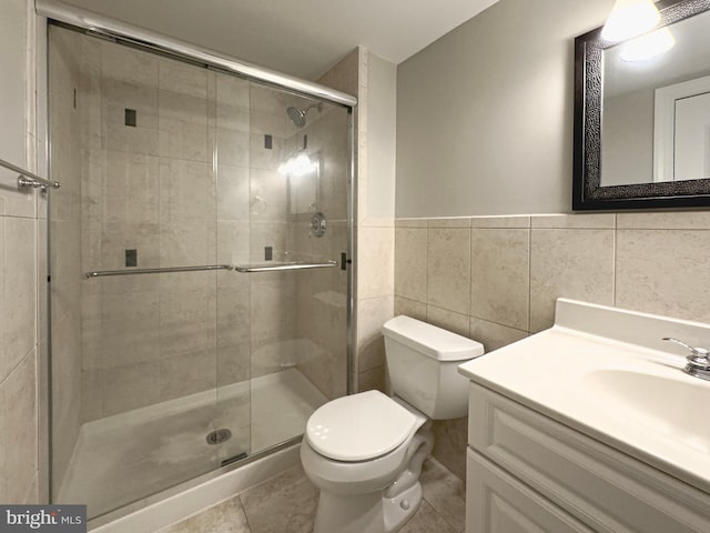 bathroom featuring tile walls, tile patterned flooring, vanity, toilet, and walk in shower