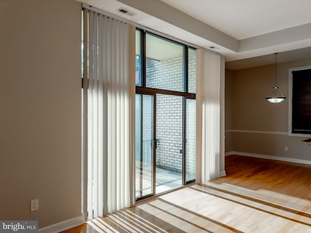 unfurnished room with hardwood / wood-style flooring and a healthy amount of sunlight