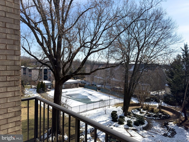 view of snow covered back of property