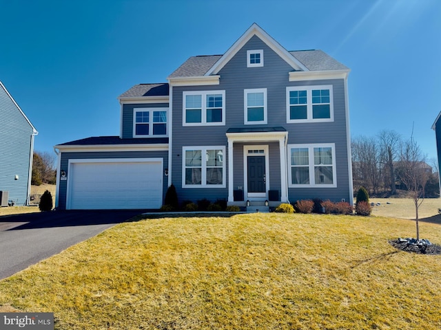 view of front of house featuring aphalt driveway, an attached garage, and a front lawn