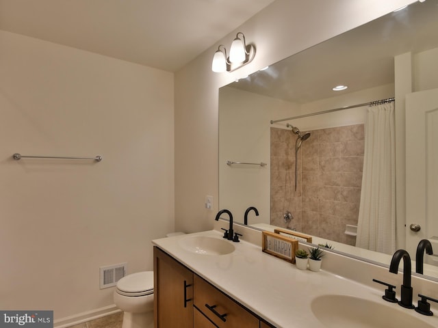 bathroom featuring double vanity, toilet, visible vents, and a sink