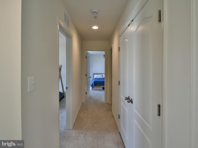 hall featuring visible vents, baseboards, recessed lighting, an upstairs landing, and light colored carpet