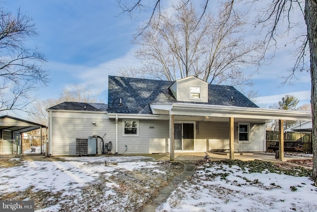 snow covered house featuring central AC