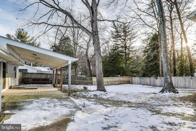 yard layered in snow featuring a wooden deck and ceiling fan