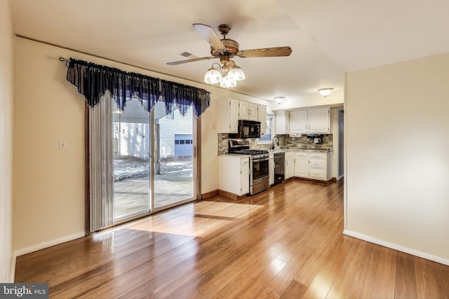 kitchen featuring black appliances, backsplash, white cabinets, ceiling fan, and light hardwood / wood-style floors