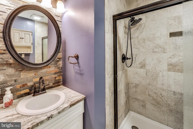 bathroom featuring tasteful backsplash, vanity, and walk in shower