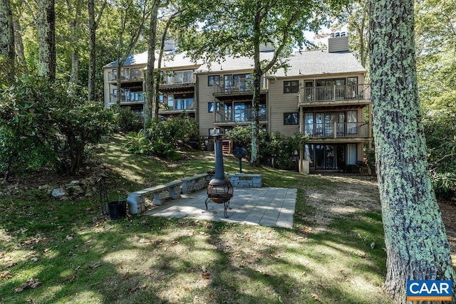 123 Eagles Ct Unit 123, Wintergreen Resort, VA 22967 - back of property featuring a fire pit, a balcony, a chimney, a patio area, and a lawn