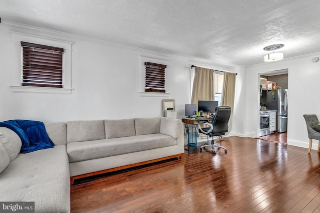 living room with hardwood / wood-style flooring, ornamental molding, and a textured ceiling