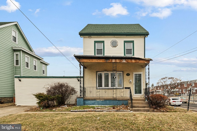 view of front of house featuring covered porch and a front yard