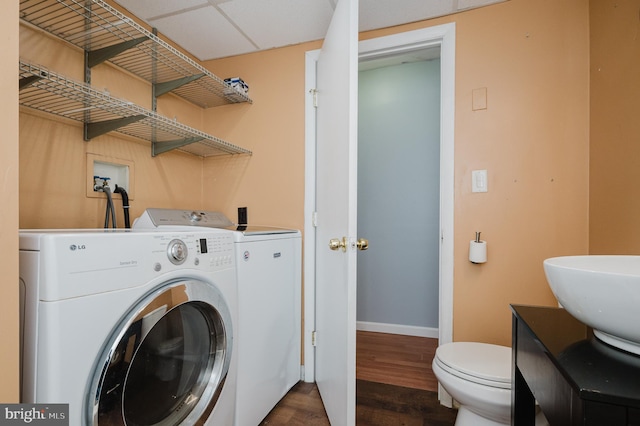 laundry room featuring dark hardwood / wood-style floors, sink, and washer and dryer