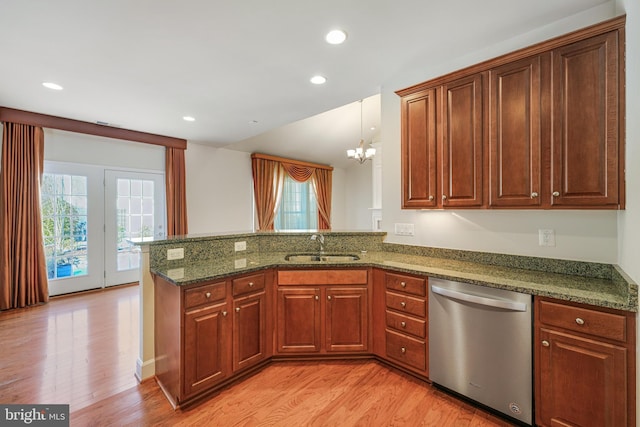 kitchen with sink, dark stone countertops, stainless steel dishwasher, kitchen peninsula, and light wood-type flooring