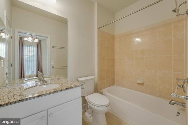 full bathroom featuring tiled shower / bath, vanity, and toilet