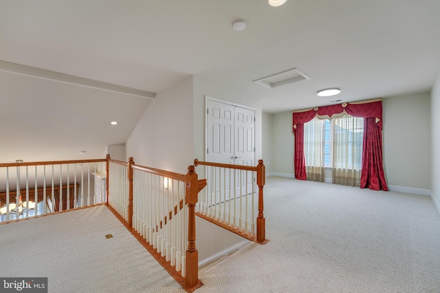 hall with vaulted ceiling and carpet flooring