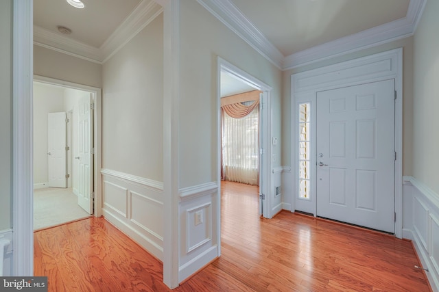 entrance foyer with light hardwood / wood-style flooring and ornamental molding