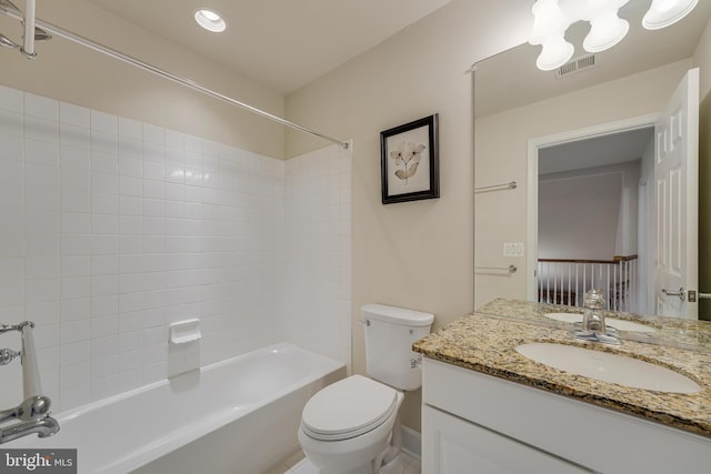 full bathroom with tiled shower / bath, vanity, and toilet