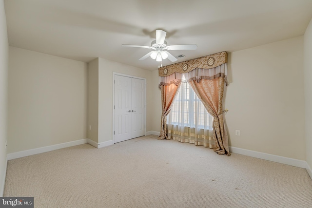 carpeted spare room with ceiling fan