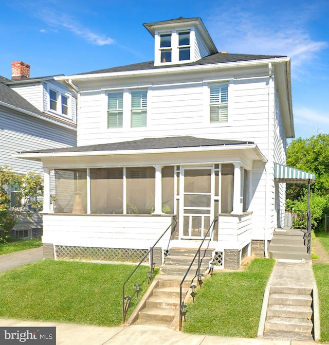 view of front of property featuring a sunroom and a front yard