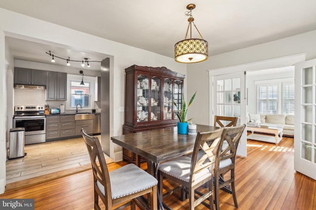 dining space with sink and light hardwood / wood-style floors