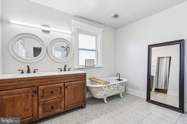 bathroom with tile patterned flooring, vanity, and a bathtub