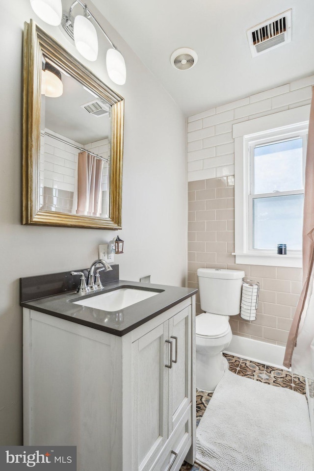 bathroom featuring vanity, curtained shower, tile walls, and toilet