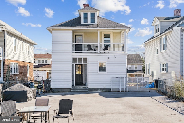 rear view of house with a patio and a balcony