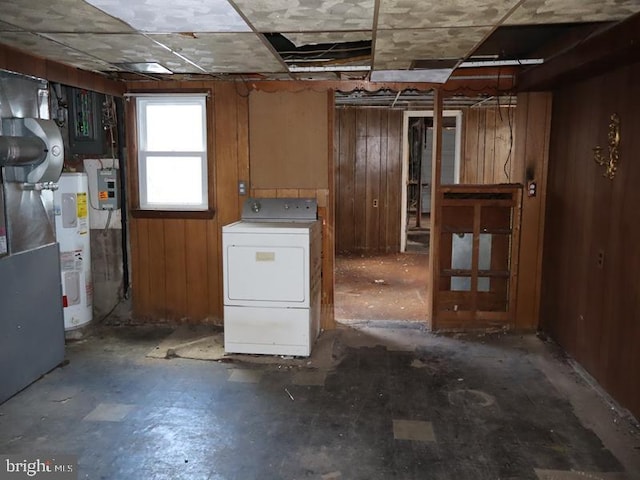 basement featuring washer / clothes dryer, water heater, and wood walls