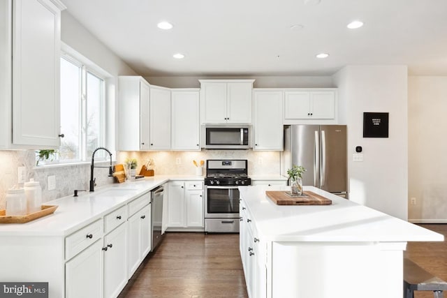 kitchen with white cabinetry, sink, a center island, and appliances with stainless steel finishes