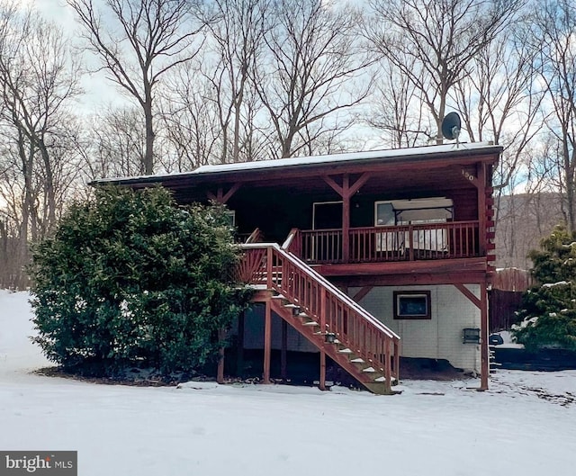 view of front facade featuring stairway, log exterior, and brick siding