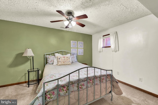 carpeted bedroom with a ceiling fan, a textured ceiling, and baseboards