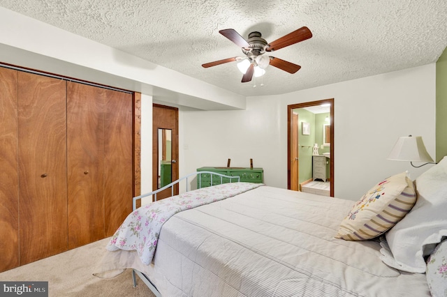 bedroom featuring a textured ceiling, carpet floors, ceiling fan, and ensuite bath