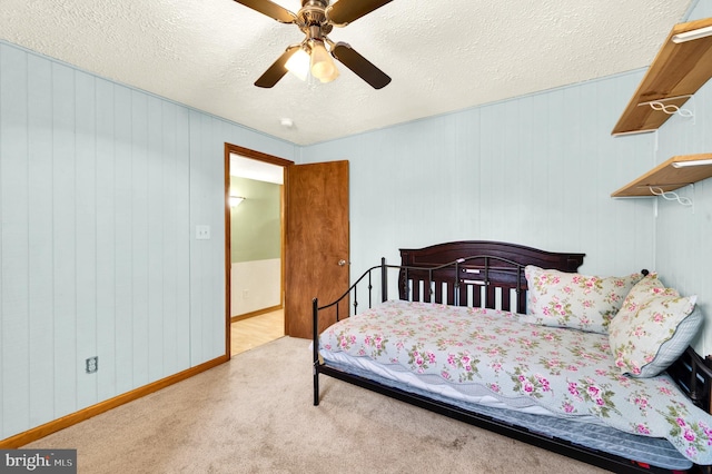 carpeted bedroom featuring ceiling fan, baseboards, and a textured ceiling