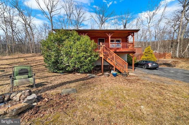 exterior space featuring driveway, stairway, and log exterior