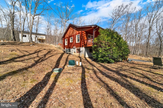 view of side of property with dirt driveway and log exterior