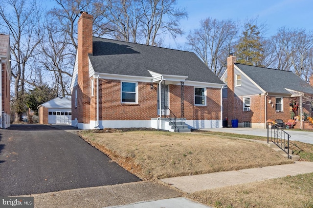 view of front of property featuring an outbuilding, a garage, and a front lawn